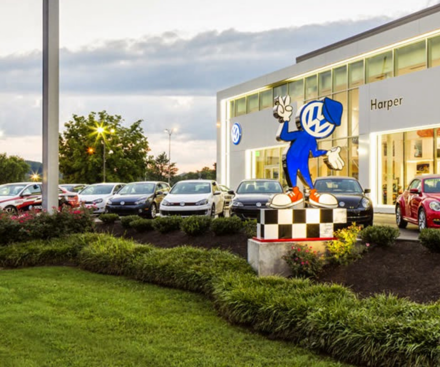 Car dealership with professional freshly cut grass, new hedges, and freshly mulched flower beds.